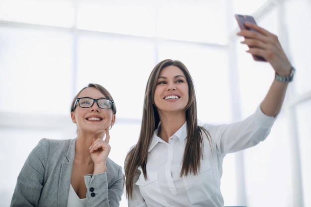 Les jeunes employés prennent des selfies sur leur lieu de travail