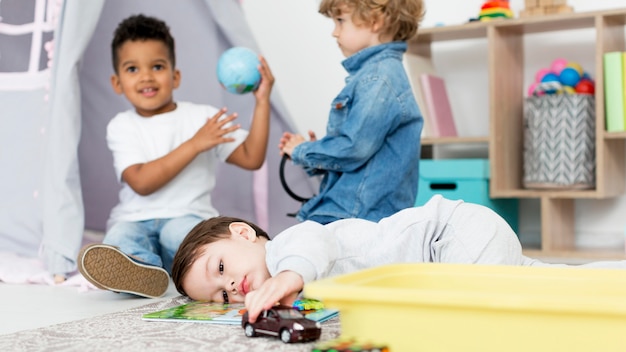 Jeunes enfants heureux jouant avec des jouets