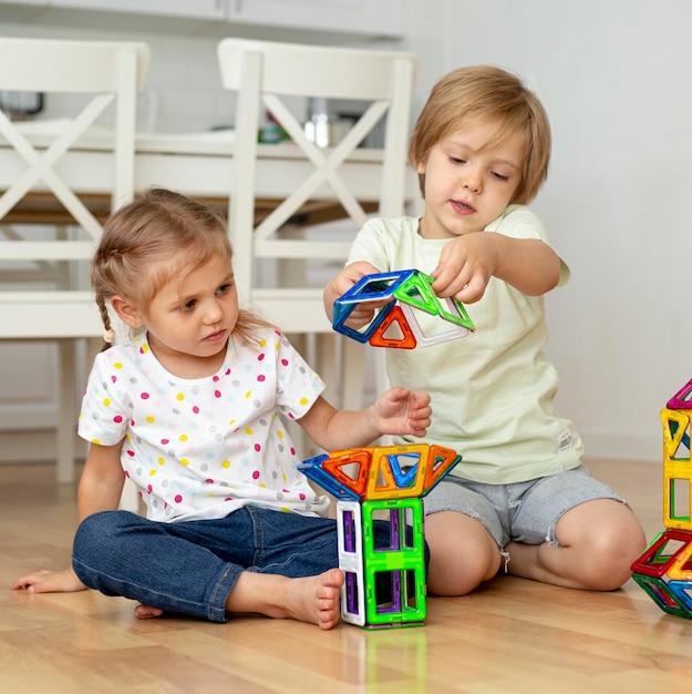 Jeunes enfants à la maison jouant avec des jouets