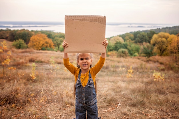 Jeunes enfants tenant une affiche sur la nature en automne