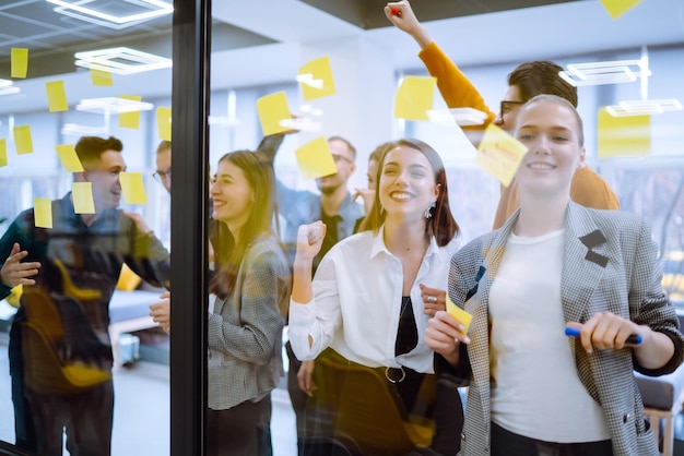 Les jeunes de l'équipe d'affaires réfléchissent ensemble à un projet d'entreprise et écrivent des tâches de stratégie