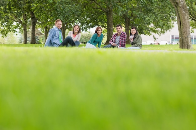 Jeunes étudiants assis sur l&#39;herbe dans le parc