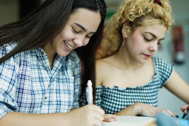 Jeunes étudiants divers apprenant ensemble à l'intérieur de la bibliothèque universitaire