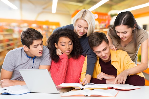 Jeunes étudiants étudiant sur fond de bibliothèque