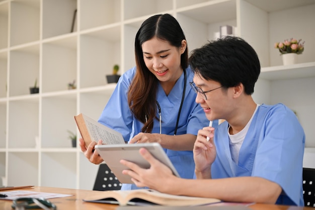 De jeunes étudiants en médecine asiatiques concentrés discutent et recherchent des informations médicales