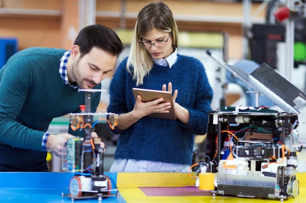 Jeunes étudiants en robotique travaillant ensemble sur un projet