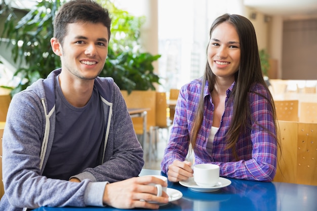 Jeunes étudiants, souriant à la caméra au café