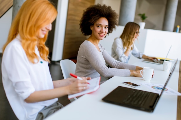 Photo jeunes femmes d'affaires au bureau