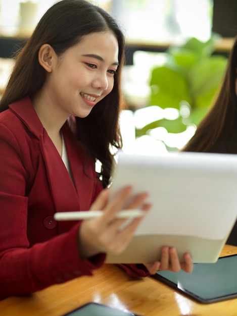 Jeunes femmes d'affaires travaillant avec des statistiques et vérifiant les rapports financiers dans un bureau moderne