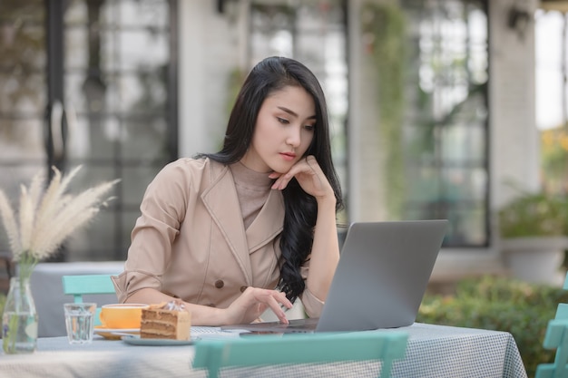 Jeunes femmes d&#39;affaires vérifiant les documents courrier sur un ordinateur portable