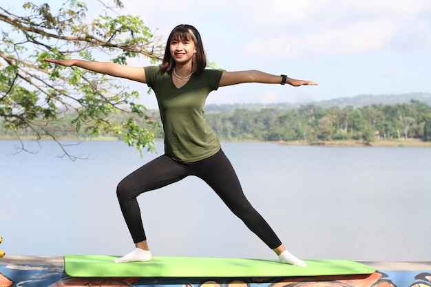 JEUNES FEMMES ASIATIQUES FAISANT DU YOGA LE MATIN