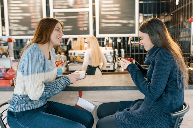 Jeunes femmes, café buvant, dans, café, filles, séance, près, barre, compteur