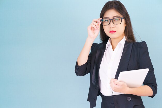 Jeunes femmes debout en costume tenant son ordinateur tablette numérique