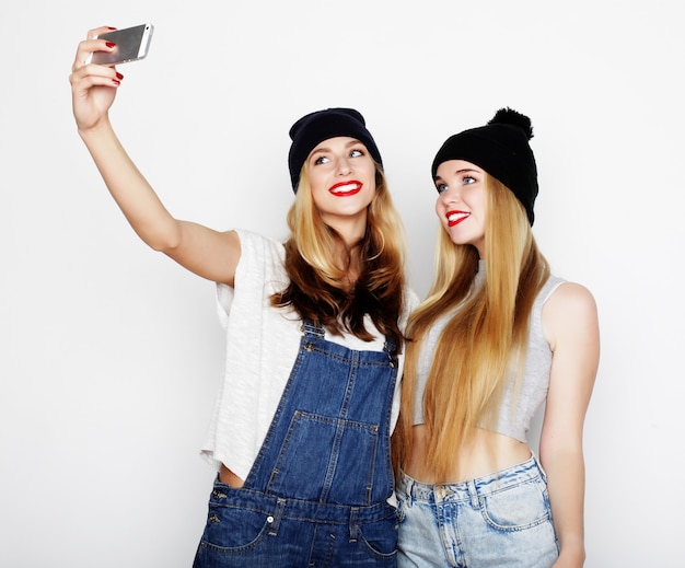 Jeunes femmes drôles prenant selfie avec téléphone mobile