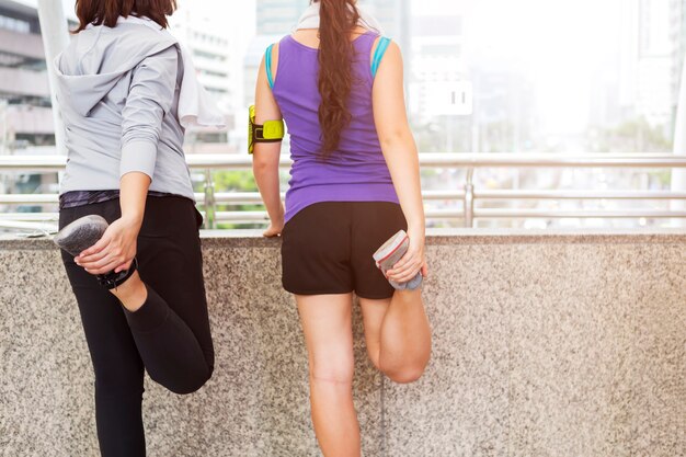 Jeunes femmes échauffement avant de courir dans la ville