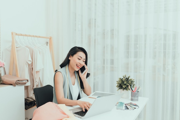 Jeunes femmes entrepreneures asiatiques / créatrice de mode travaillant dans son atelier