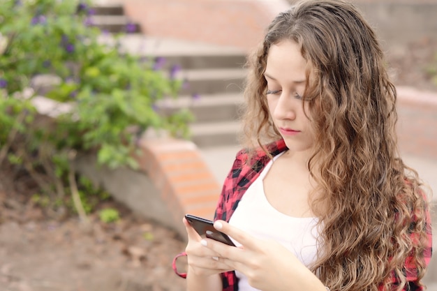 Jeunes femmes envoyant un message avec un smartphone.