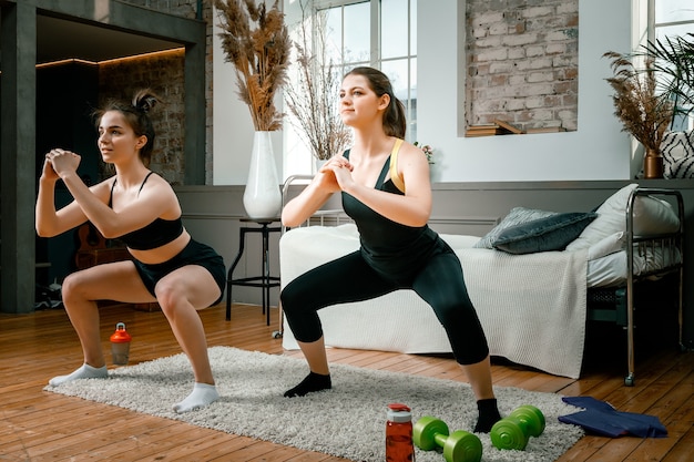 Les jeunes femmes font du sport à la maison, s'entraînent en ligne