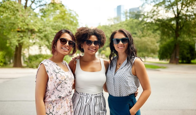 jeunes femmes heureuses en lunettes de soleil au parc d'été