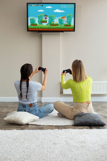 Jeunes femmes jouant à des jeux vidéo ensemble