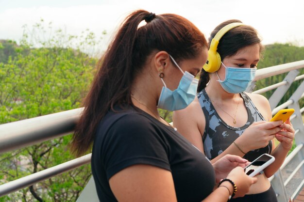 Les jeunes femmes en masque de protection choisissent la musique avant de courir en ville