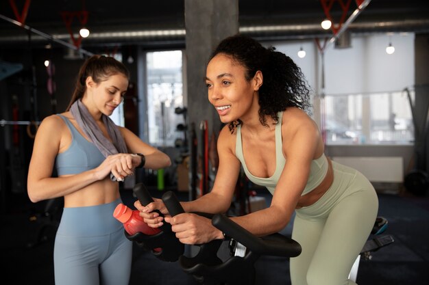 Photo jeunes femmes participant à un cours de spinning