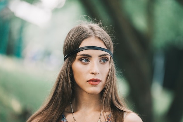 Jeunes femmes pensives hippie à l'arrière-plan du feuillage vert