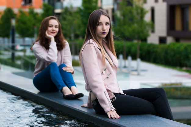 jeunes femmes posant sur une fontaine d'eau