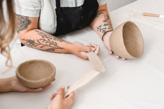 Les jeunes femmes en pot de terre en atelier de poterie