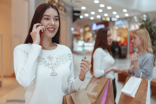 Jeunes femmes profitant du shopping ensemble au centre commercial