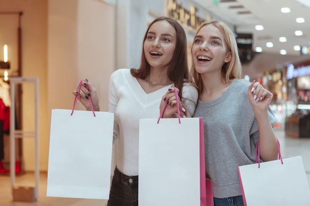 Jeunes femmes profitant du shopping ensemble au centre commercial