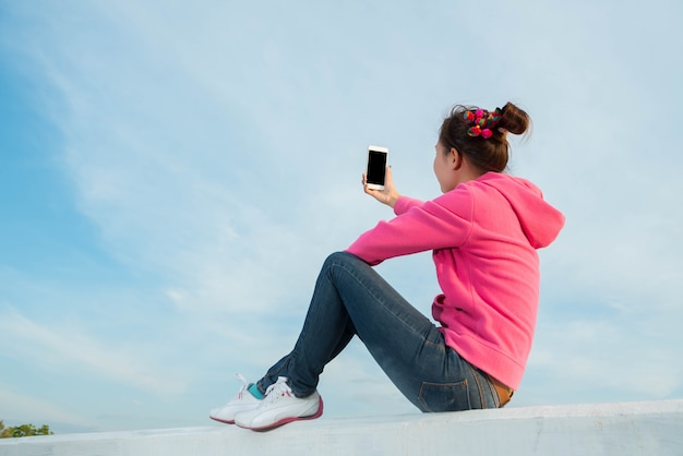 Les jeunes femmes sont un beau ciel de selfie au coucher du soleil