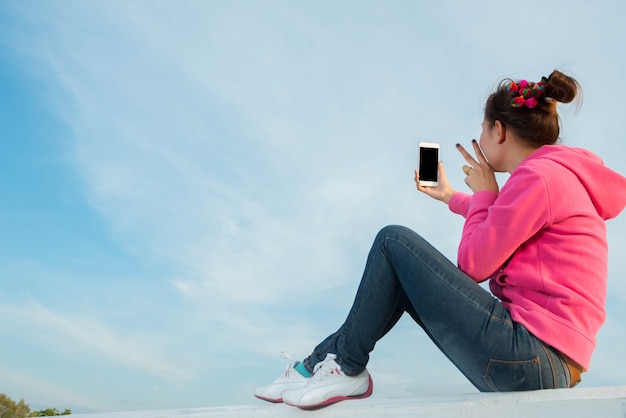 Les jeunes femmes sont un beau ciel de selfie au coucher du soleil