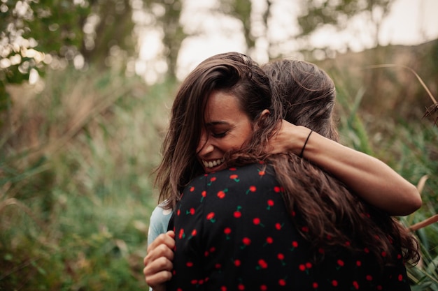 Des jeunes femmes souriantes embrassées par des plantes