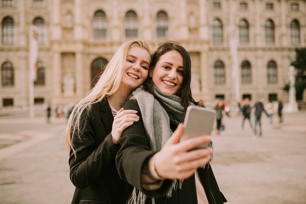 Les jeunes femmes touristes prenant selfie avec photo mobile dans la rue dans le centre de Vienne, Autriche