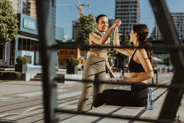 Jeunes femmes en vêtements de sport faisant de l'exercice sur une promenade fluviale