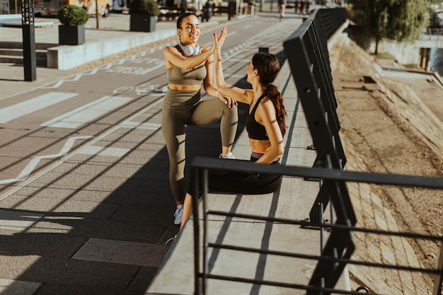 Jeunes femmes en vêtements de sport faisant de l'exercice sur une promenade fluviale