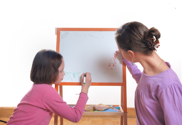 Jeunes filles dessinant sur le tableau blanc