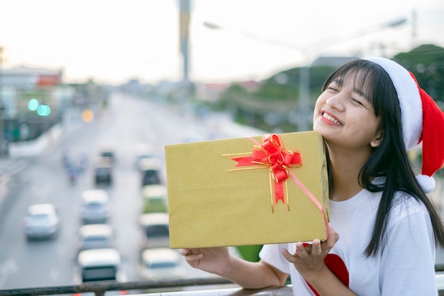 Les jeunes filles heureuses portent le chapeau de Noël sur le fond de vue de ville.