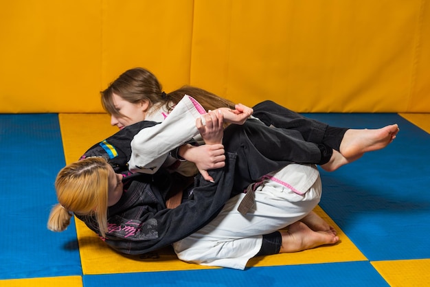 Les jeunes filles pratiquent le jiu jitsu brésilien dans la salle de gym