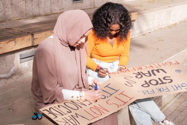 Des jeunes font des affiches pour une manifestation contre la guerre Concept de paix