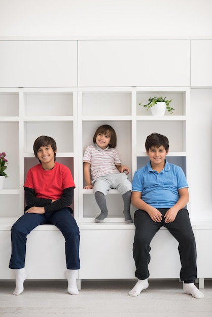 de jeunes garçons heureux s'amusent en posant sur une étagère dans une nouvelle maison moderne