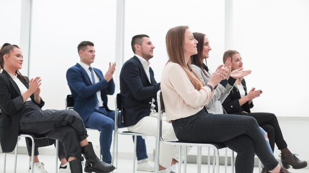 Jeunes gens d'affaires applaudissant lors d'une photo de séminaire d'entreprise avec un fond