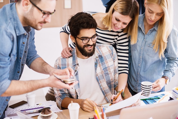 Photo jeunes gens d'affaires gais et créatifs réussis à la recherche d'une analyse de leurs résultats de travail