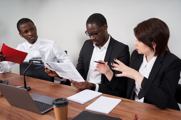 Jeunes gens d'affaires heureux travaillant ensemble dans un bureau moderne, concept de travail d'équipe multiethnique