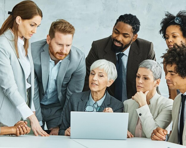 jeunes gens d'affaires réunion bureau travail d'équipe succès de groupe d'entreprise senior collègue mature ordinateur portable ensemble diversité