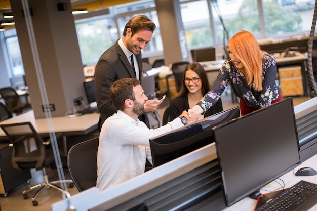 Jeunes gens d'affaires se serrant la main au bureau