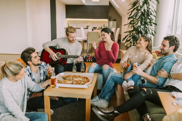 Jeunes gens ayant une pizza party dans la chambre