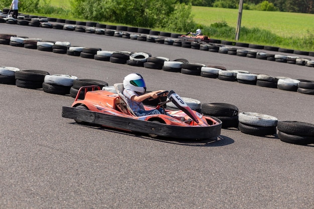 Photo les jeunes go kart racer sur la bonne voie image dynamique d'adolescent se déplaçant rapidement par un kart avec effet de flou de mouvement