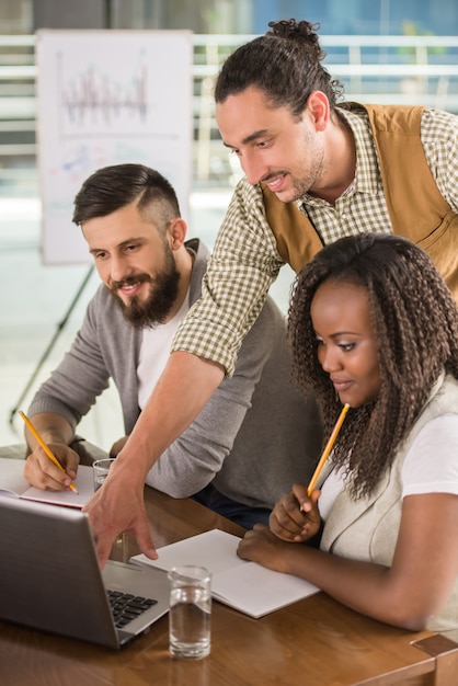 Les jeunes habillés décontracté assis à la table de bureau.